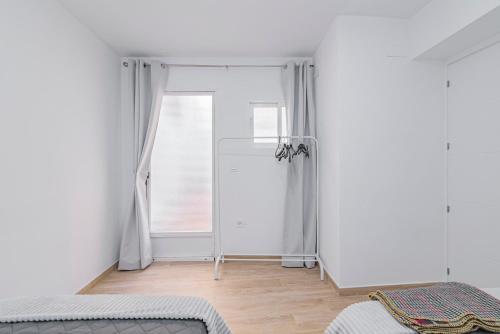 a white room with a mirror and a window at Casa de la Abuela in Quéntar