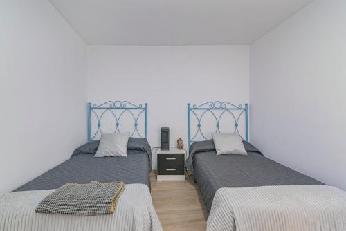 two beds sitting next to each other in a bedroom at Casa de la Abuela in Quéntar
