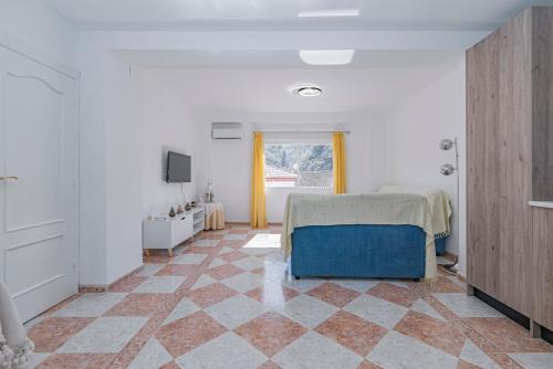a bedroom with a bed and a tiled floor at Casa de la Abuela in Quéntar