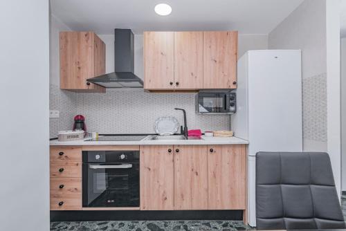 a kitchen with wooden cabinets and a refrigerator at Casa de la Abuela in Quéntar