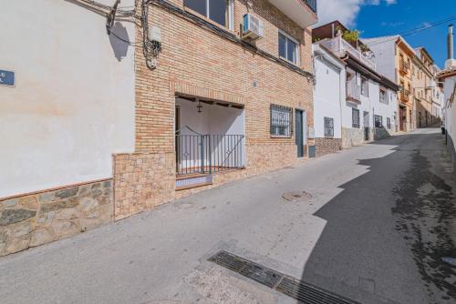 an empty street in an alley with a brick building at Casa de la Abuela in Quéntar