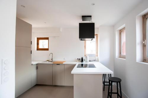 une cuisine blanche avec un évier et un comptoir dans l'établissement The Lookout Bourg Saint Maurice, à Bourg-Saint-Maurice