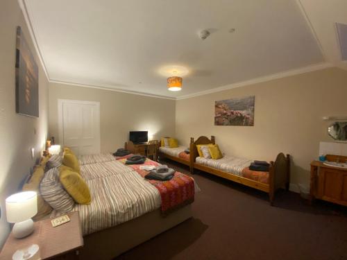 a bedroom with two beds and a desk and a table at Forse of Nature in Latheron
