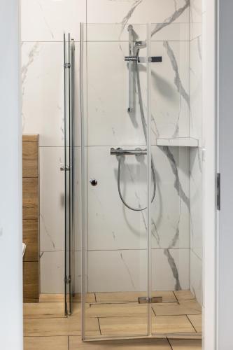 a shower with a glass door in a bathroom at Domki Gold-Time Niechorze in Niechorze