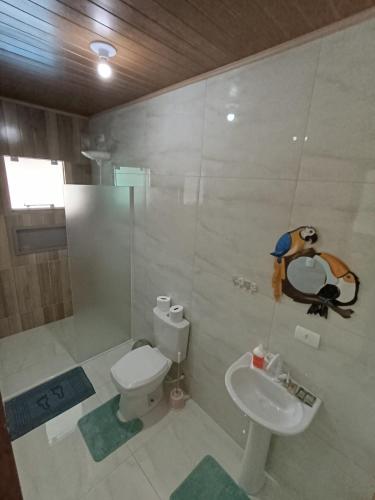 a bathroom with a white toilet and a sink at Reino Encantado Dona Siroba in Morretes