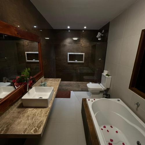 a bathroom with a tub and a sink and a toilet at Pousada Águas de Tamandaré in Tamandaré