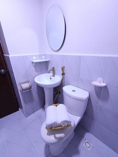 łazienka z toaletą, umywalką i lustrem w obiekcie Z Luxe Studio w Cebu