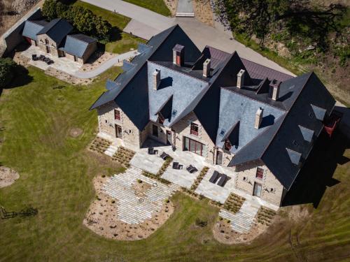 an aerial view of a large house with black roofs at Domaine de Locguénolé & Spa - Relais & Chateaux in Kervignac