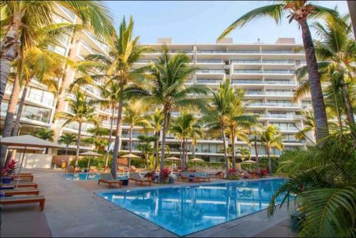 a hotel with palm trees and a swimming pool at Nima Bay, Marina Vallarta in Puerto Vallarta