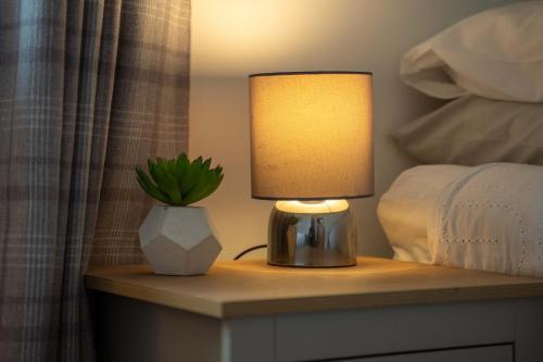 a lamp on a table with a potted plant on it at Kilmallie House in Caol