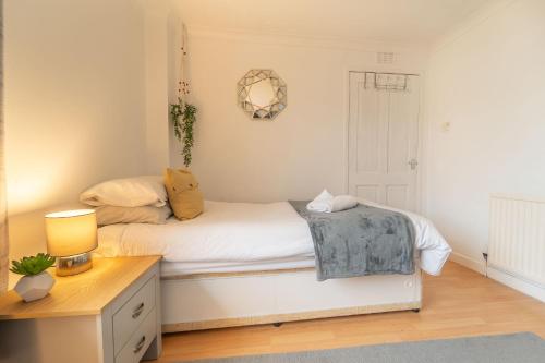 a small bedroom with a white bed and a desk at Kilmallie House in Caol