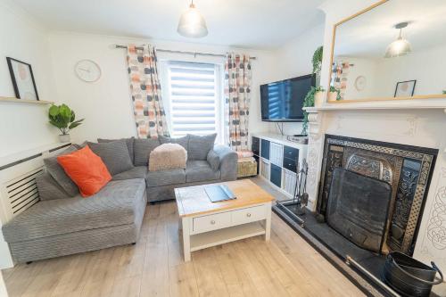 a living room with a couch and a fireplace at Kilmallie House in Caol