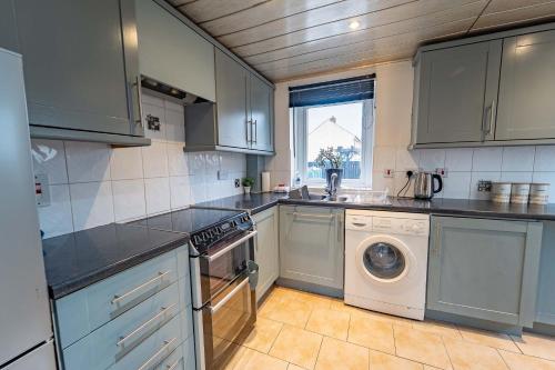 a kitchen with a washing machine and a dishwasher at Kilmallie House in Caol