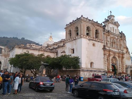a large church with cars parked in front of it at Pacífico Jaguar Antigua in Antigua Guatemala