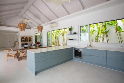 a kitchen with blue and white cabinets and a table at Enchanting 4Br Villa Private Pool & Breakfast incl in Mae Nam