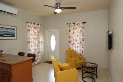a living room with yellow chairs and a table at SYL Apartment in North Side
