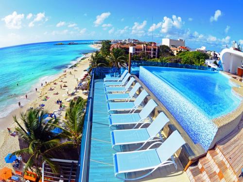 un complejo con piscina y playa en The Carmen Hotel - Ocean Front, en Playa del Carmen