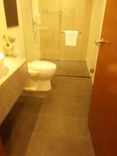 a bathroom with a toilet and a shower at Gloria Swiss Hotel & Apartment Sandakan in Sandakan