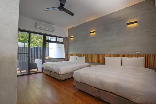 1 dormitorio con 2 camas y ventana grande en Ruisui Sunshine Hot Spring B&B, en Ruisui