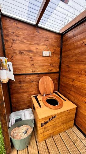 a bathroom with a toilet in a wooden structure at Stargazer Bell Tent in Northrepps