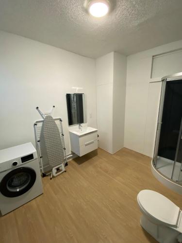 - un salon blanc avec une télévision et une chaise dans l'établissement New T2 Clermont Salins, à Clermont-Ferrand