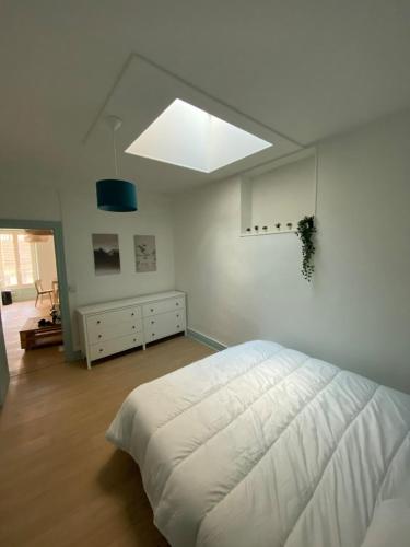 une chambre avec un grand lit blanc dans une pièce dans l'établissement New T2 Clermont Salins, à Clermont-Ferrand