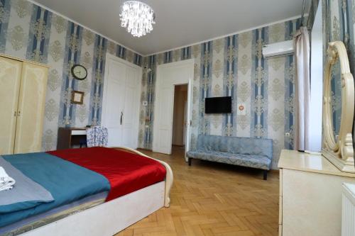 a bedroom with a bed and a tv and a chair at Leon Rooms in Tbilisi City