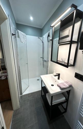 a bathroom with a white sink and a shower at Lütte Pension in Egestorf