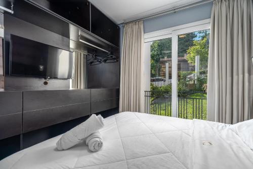 a bedroom with a large bed and a large window at Loft One no Centro by Achei Gramado in Gramado