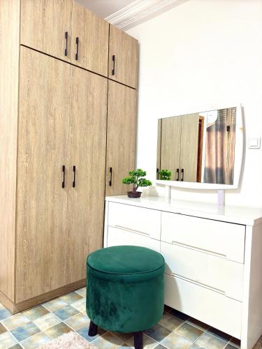 a bathroom with wooden cabinets and a green ottoman at Hope guests home in Douala