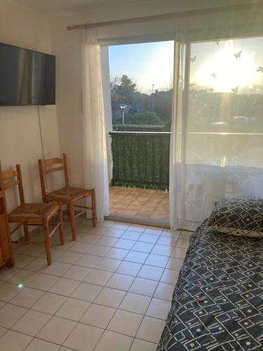 une chambre avec un lit et une porte coulissante en verre dans l'établissement Résidence, à Saint Cyprien Plage