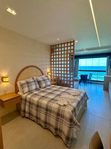 a bedroom with a bed and a view of the ocean at Flat beira mar em Tamandaré Carneiros - Kauai in Tamandaré