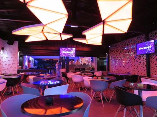 a restaurant with tables and chairs and lights at Superbe studio avec Piscine, au coeur de la Marina! Village Soleil ! Proche Aéroport & Ferry in Le Gosier