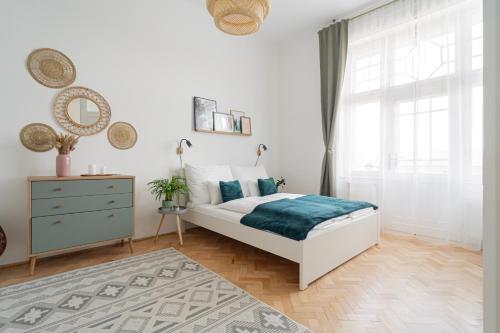 a bedroom with a bed and a dresser and a window at Duna Panorama Apartment in Budapest