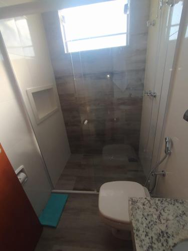 a small bathroom with a toilet and a shower at Flat Familiar em Capitolio Charlene Paiva in Capitólio