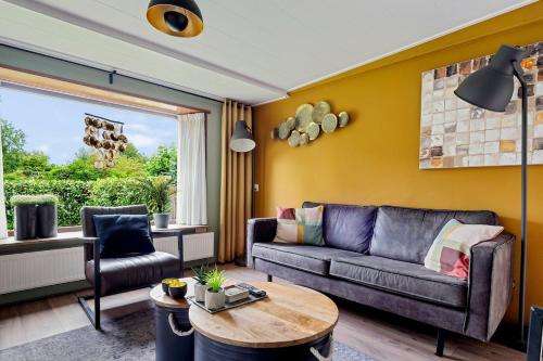 a living room with a couch and a table at Luxe chalet met jacuzzi en sauna in Erm