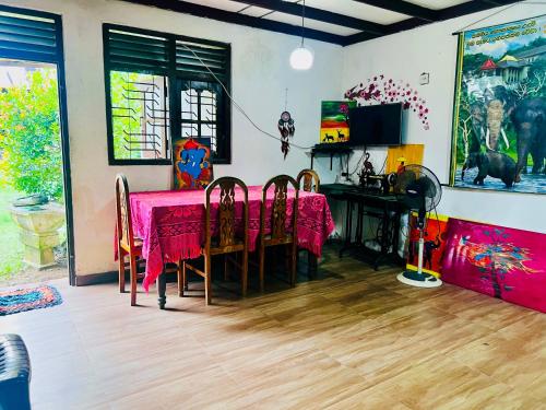 a dining room with a pink table and chairs at DK Paddy Field Villa in Unawatuna in Unawatuna