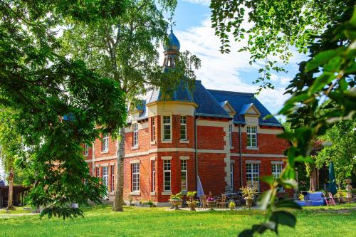 a large red brick building with a tower on top at Herrenhaus Brookhusen nahe Rostock & Ostsee in Benitz