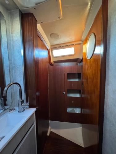 a bathroom with a sink and a wooden door at Charming Sailboat in Lisbon