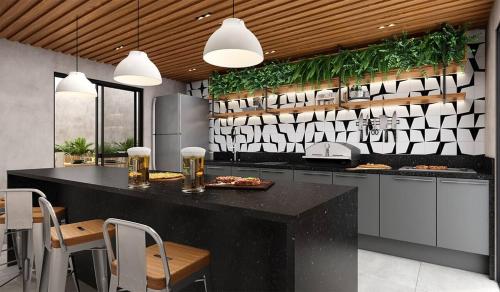 a kitchen with a large black counter with chairs at Apto Beira-Mar Icarai RJ Curta e longa temporada in Niterói
