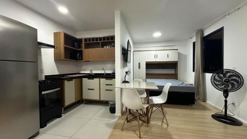 a kitchen with a table and a bedroom with a bed at Apto Beira-Mar Icarai RJ Curta e longa temporada in Niterói