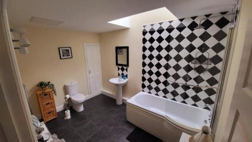 a bathroom with a black and white checkered wall at 2 hicks lane, apartment 2 in Whitehaven
