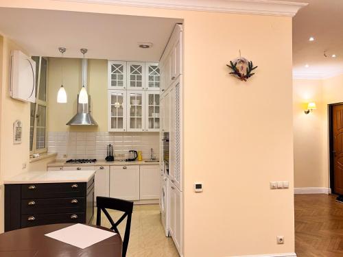 a kitchen with white cabinets and a table at Апарт-отель "ГАЛАГОВЪ" in Uzhhorod