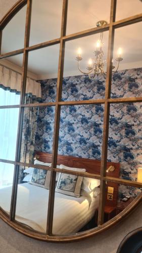 a bedroom with a bed through a large mirror at London Lodge Hotel in London
