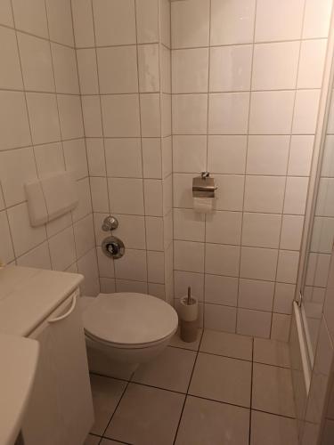 a white bathroom with a toilet and a sink at Ostseemeerchen in Zingst