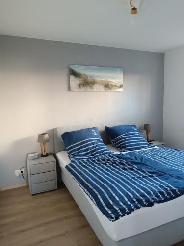 a bedroom with a bed with blue comforter and pillows at Ostseemeerchen in Zingst