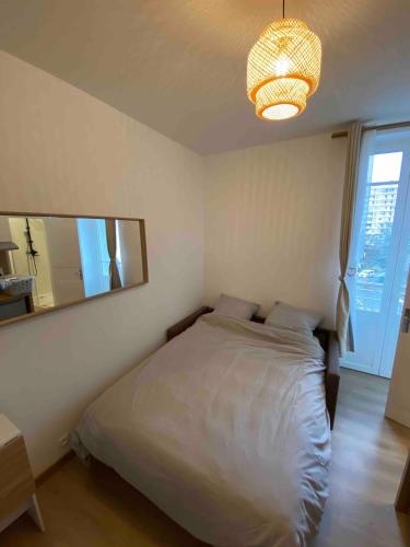 une chambre avec un lit et un grand miroir dans l'établissement Studio équipé proche Thermes Royat, à Chamalières