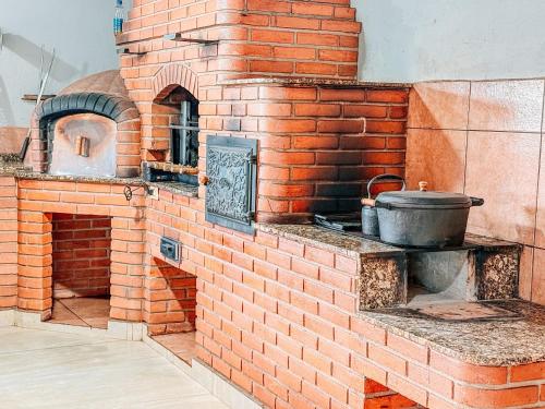 a brick oven with a pot on a counter at Refúgio Natureza - Lazer completo para sua família in Monte Sião