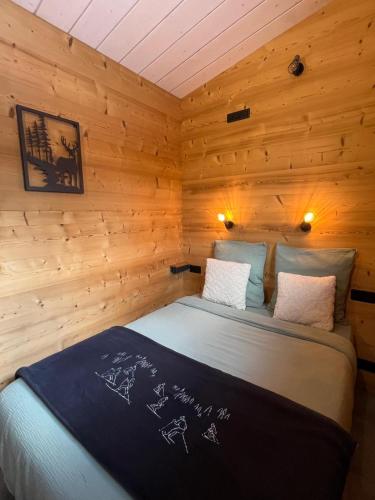 une chambre avec un lit dans une pièce en bois dans l'établissement Cottage contemporain Cosy & Chic, à Prémanon