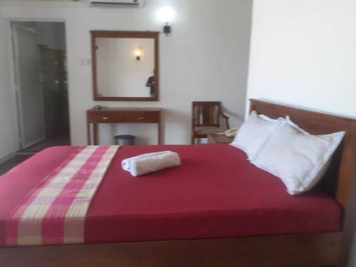 a bedroom with a bed with a red blanket and a mirror at Sanford Hotel & Restaurant Colombo in Wattala